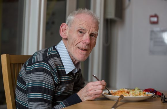 Elderly man eating a meal